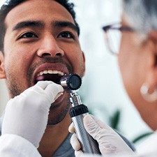 Dentist looking in a patient’s mouth
