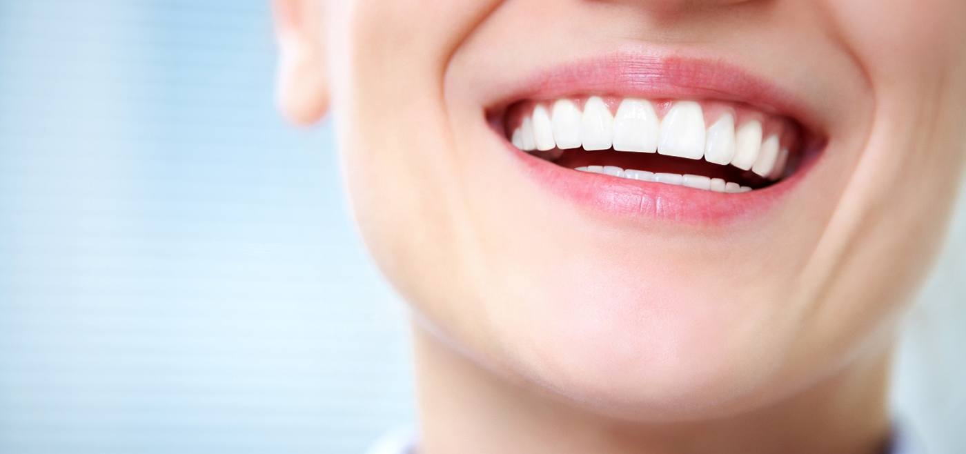 Closeup of female smiling with straight, white teeth