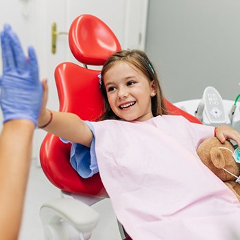 Young girl high-fives her Allen children’s dentist