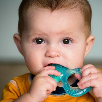 Baby chewing on teething toy in need of frenectomy for lip and tongue tie