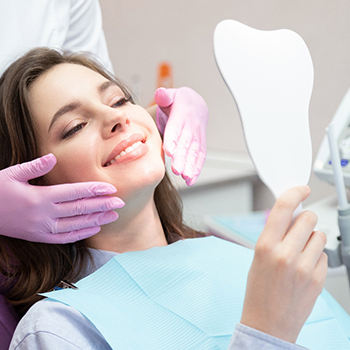 patient smiling while looking in mirror 