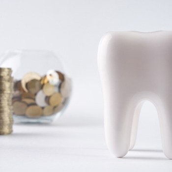 Tooth next to a pile of coins