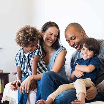 Family smiling while on the couch in Allen 