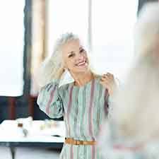 Woman smiling in her mirror and flipping her hair