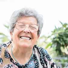 Woman smiling with plants in the background
