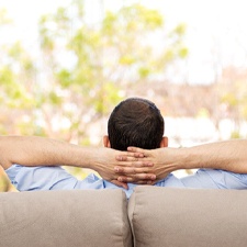 Man resting on couch after getting dental implants in Allen, TX