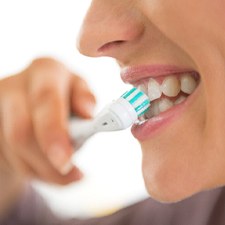 Woman with dental implants in Allen, TX brushing teeth