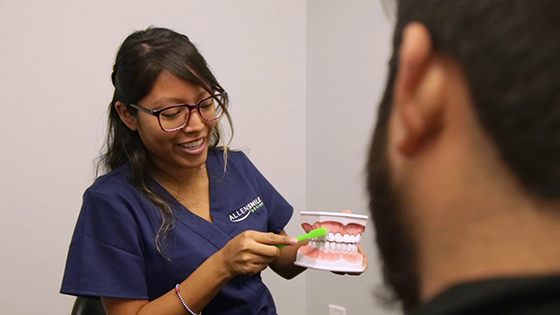 Allen dental team member holding a model of the teeth