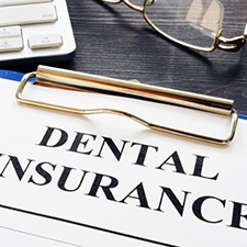 dental insurance form on a blue clipboard 