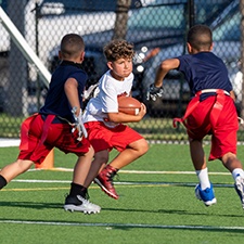 Boys in uniforms on a field playing football