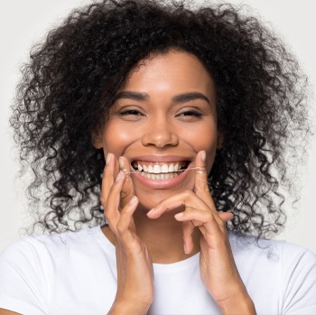 Woman flossing teeth to avoid periodontal disease