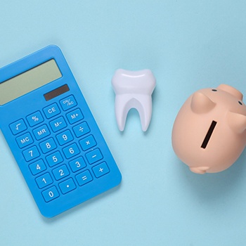 Calculator tooth and piggy bank on blue background