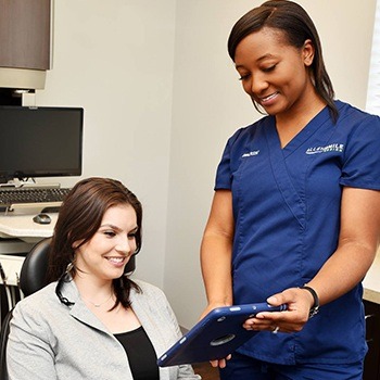 Dental team member showing patient intraoral images on tablet computer