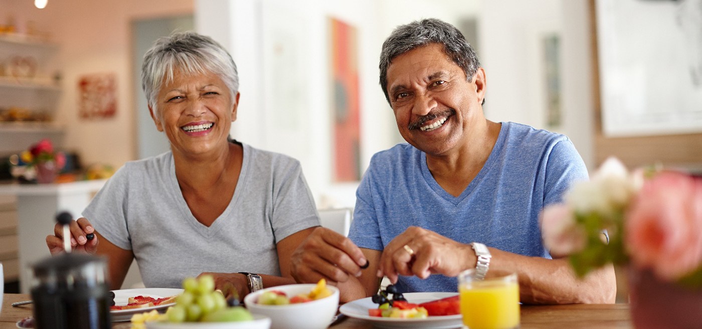 Middle-aged couple smiling and eating healthy lunch after visiting United Healthcare dentist in Allen 