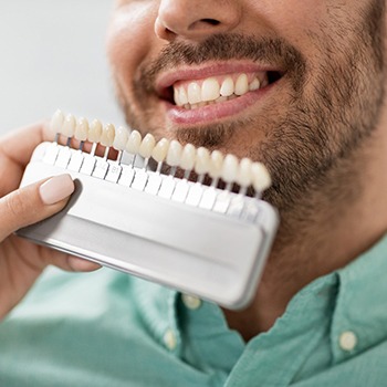 Dentist matching patients teeth to veneer shades