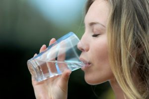 Woman keeps her smile healthy by drinking water, thanks to Allen dentist