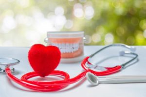 Allen dentist lays out model teeth, stethoscope, and heart shape on table