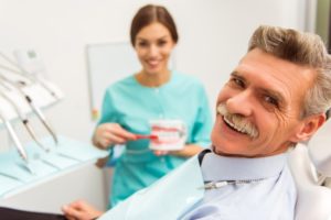 older man learning about dentures in Allen from his dentist