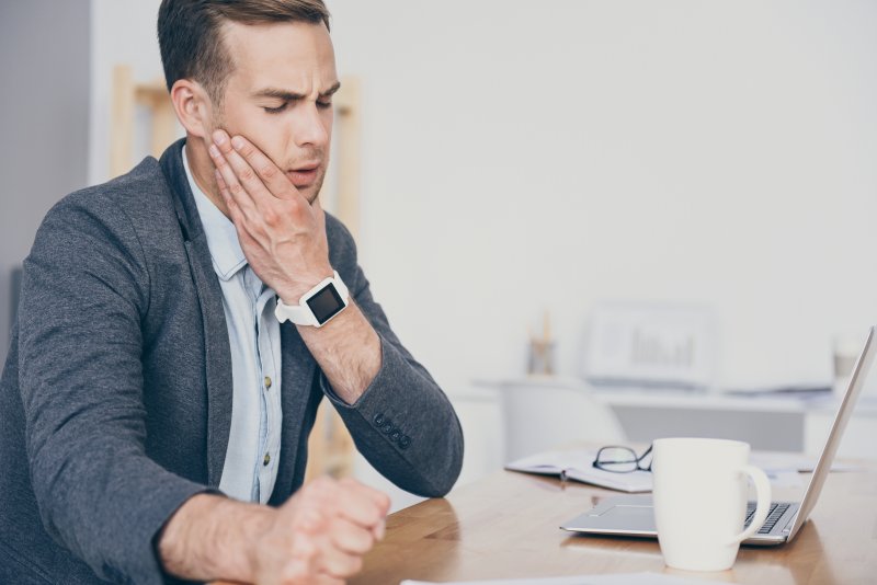 Man experiencing toothache at office