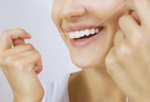 young woman flossing teeth