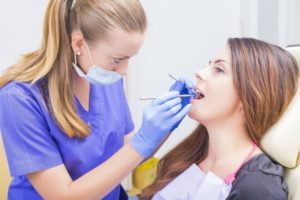 a dentist examining a patient’s mouth for a cavity