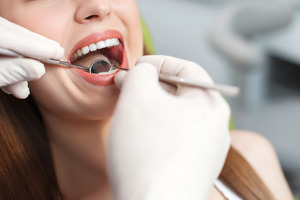 Close-up of woman having teeth examined by dentist