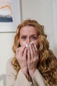 Woman with allergies blowing her nose