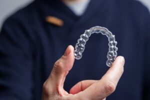 Close up of person holding clear aligner