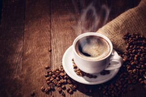 Cup of coffee and coffee beans on a table