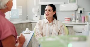 Dental team member filling out documents during patient’s consultation 